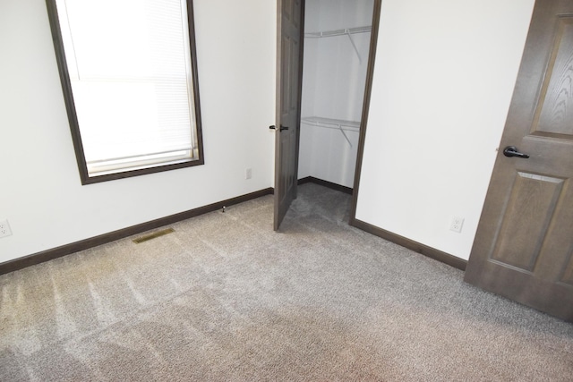 unfurnished bedroom featuring a closet and light colored carpet