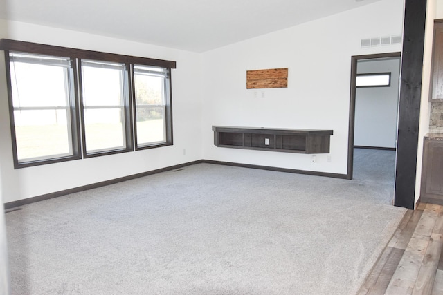 unfurnished living room with light hardwood / wood-style flooring and lofted ceiling