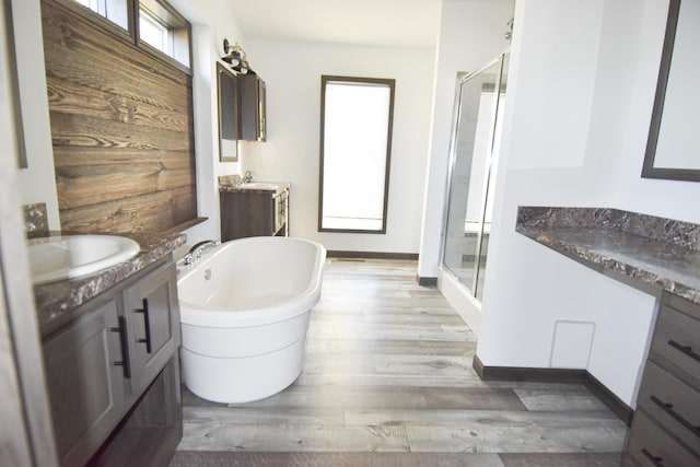 bathroom with hardwood / wood-style floors, vanity, and plus walk in shower