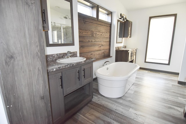 bathroom with hardwood / wood-style floors, vanity, and a bath