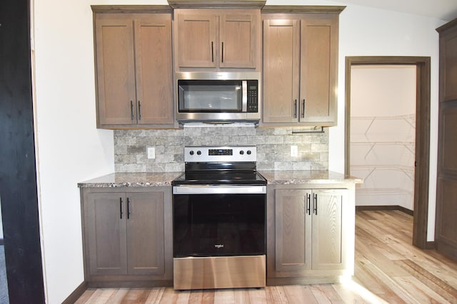 kitchen featuring appliances with stainless steel finishes, lofted ceiling, light hardwood / wood-style floors, and tasteful backsplash