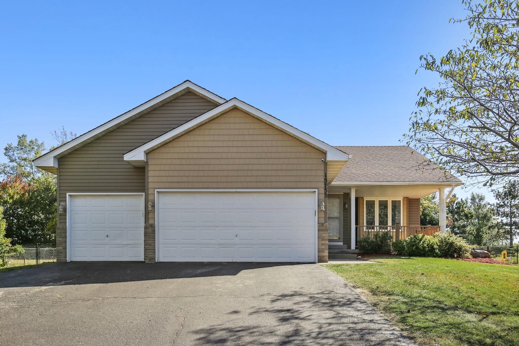 ranch-style house with a front yard, a garage, and a porch