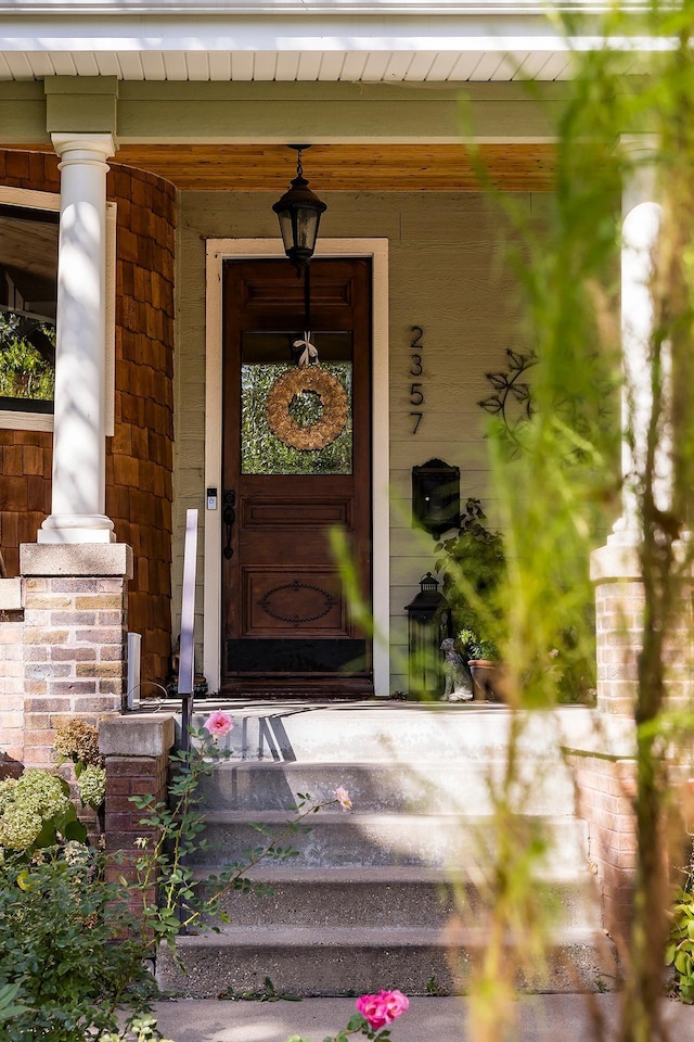 view of exterior entry featuring covered porch