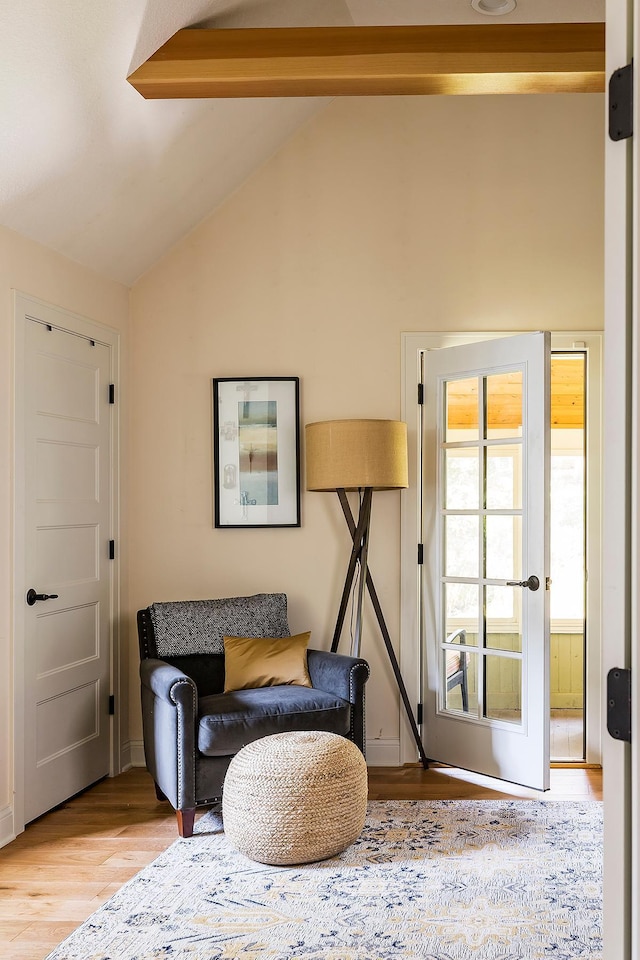 sitting room with lofted ceiling with beams and light hardwood / wood-style floors