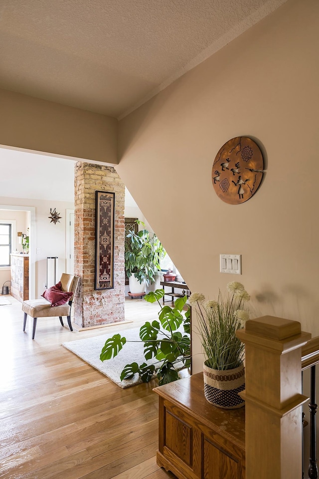 interior space with a textured ceiling and hardwood / wood-style flooring