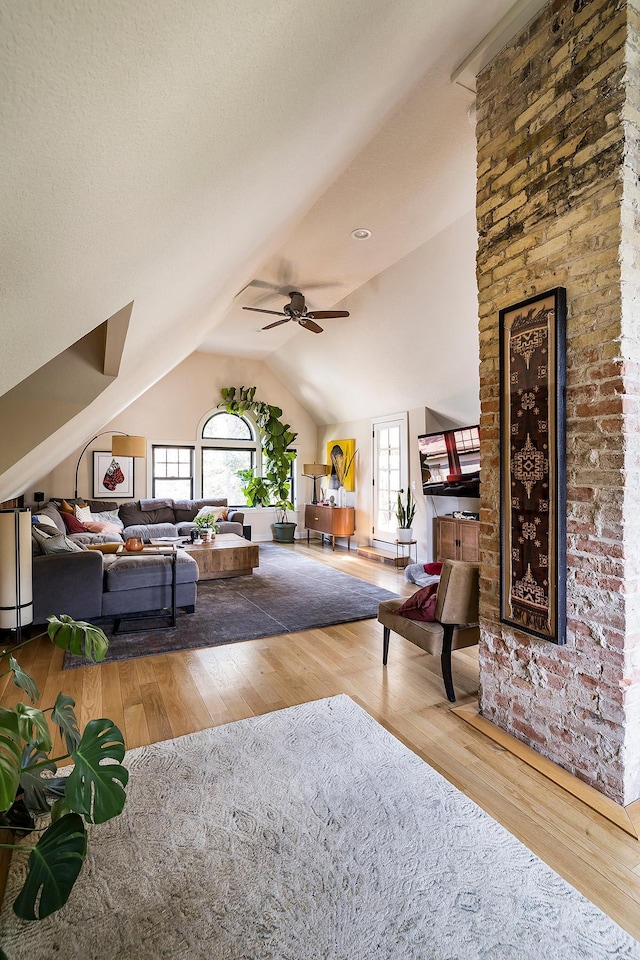 living room featuring lofted ceiling, wood-type flooring, and ceiling fan