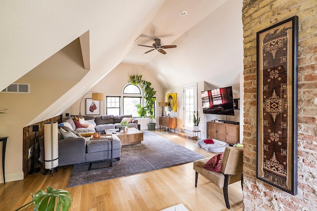 living room with hardwood / wood-style floors, vaulted ceiling, and ceiling fan