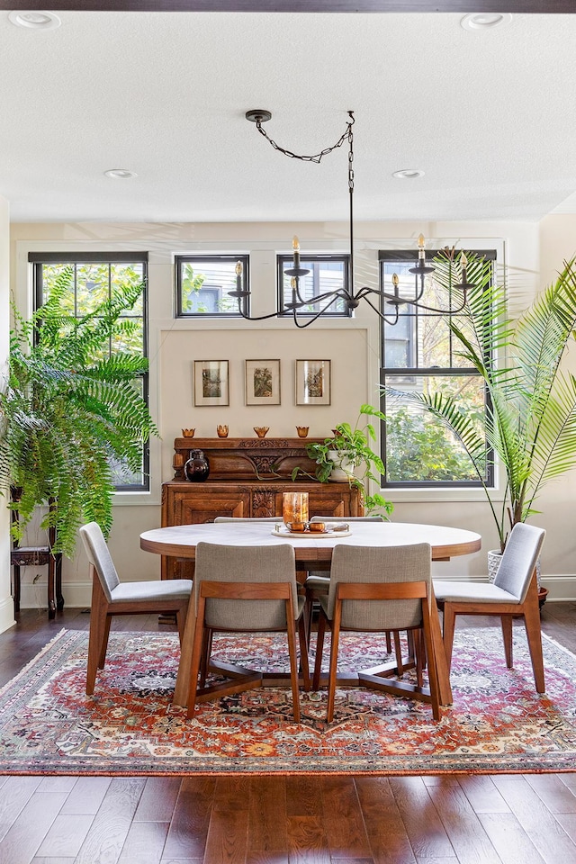 dining space with a notable chandelier, hardwood / wood-style flooring, and a textured ceiling