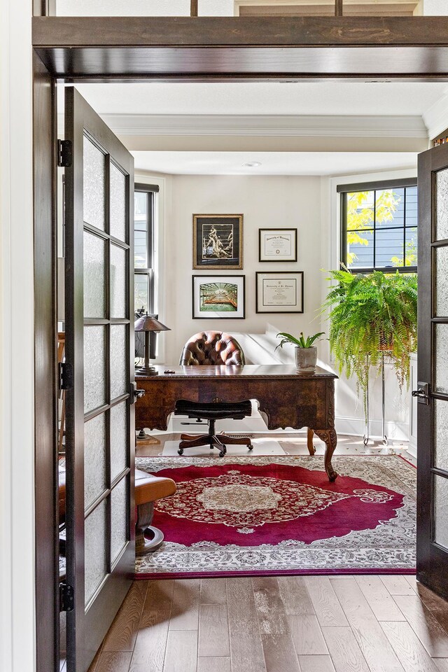 office with french doors, crown molding, and hardwood / wood-style flooring