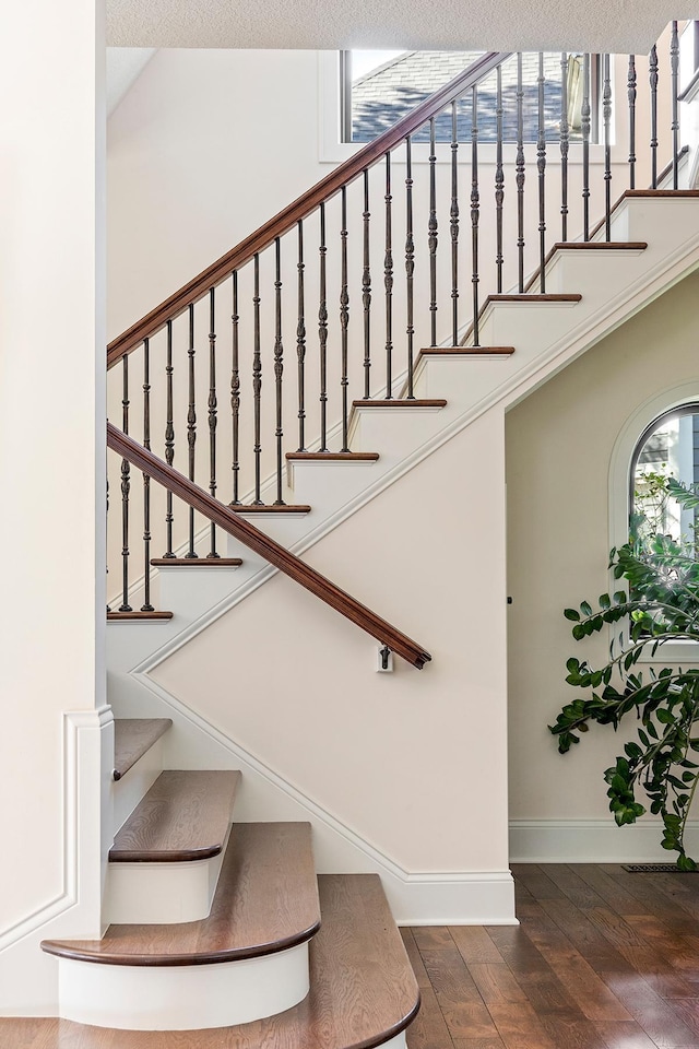 staircase featuring hardwood / wood-style flooring and a textured ceiling