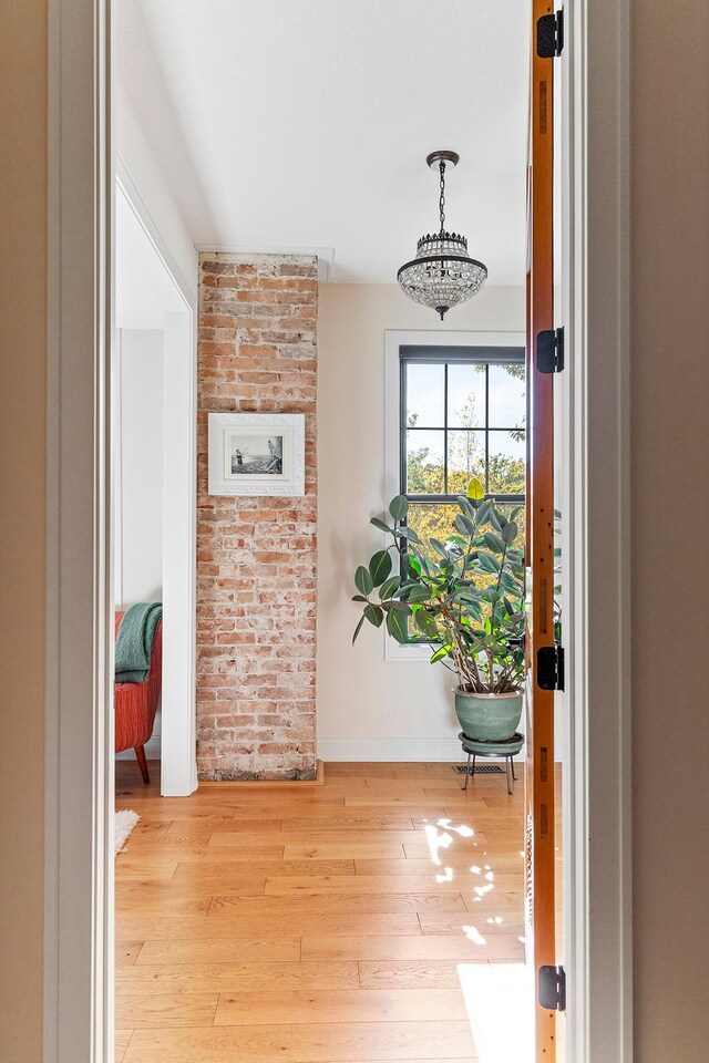 doorway to outside featuring light hardwood / wood-style floors and an inviting chandelier