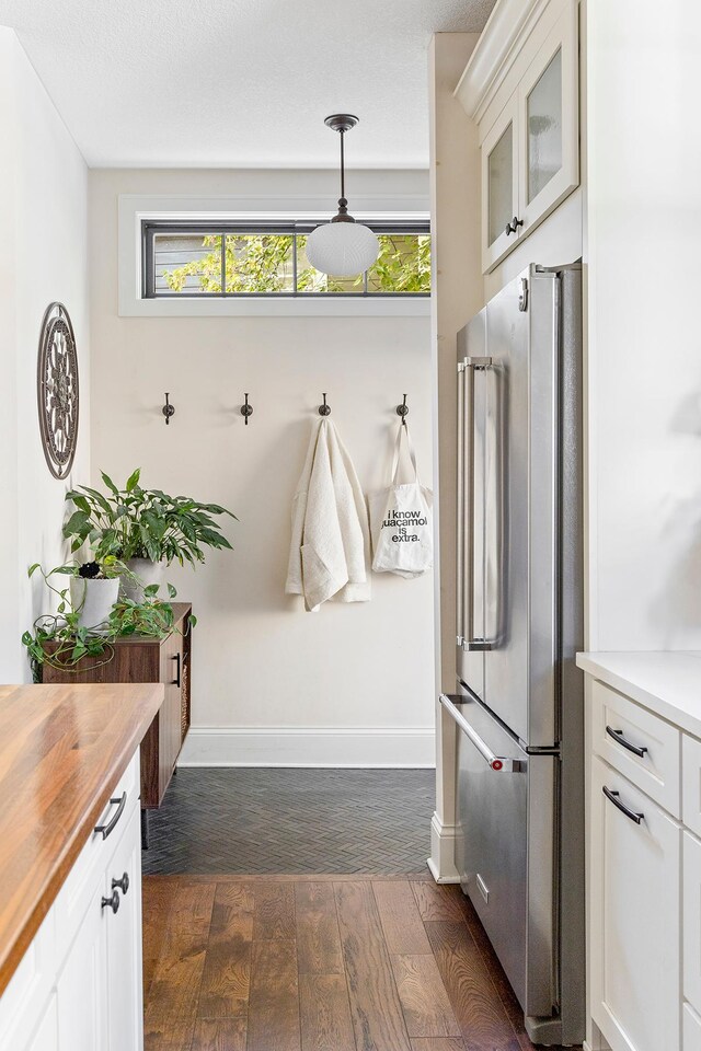 mudroom with dark wood-type flooring and a textured ceiling