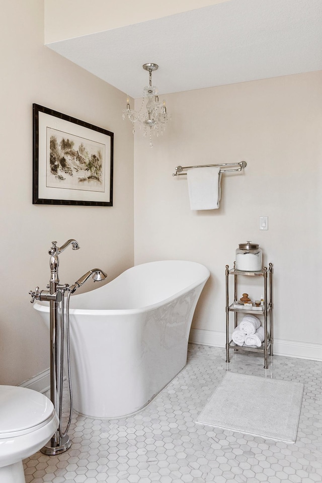 bathroom featuring a notable chandelier, tile patterned flooring, toilet, and a washtub