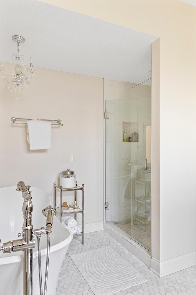 bathroom featuring a notable chandelier, plus walk in shower, and tile patterned flooring