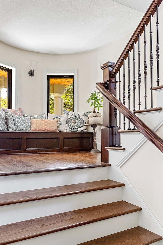 staircase featuring a textured ceiling and plenty of natural light