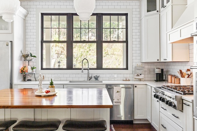 kitchen featuring sink, white cabinets, and butcher block counters