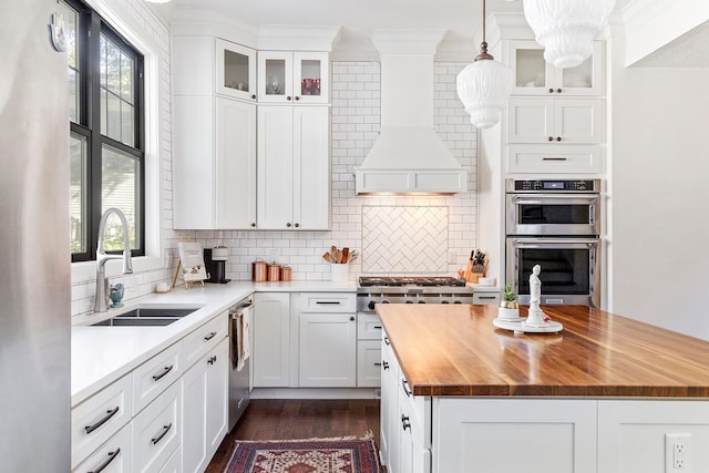 kitchen with appliances with stainless steel finishes, decorative light fixtures, sink, and plenty of natural light