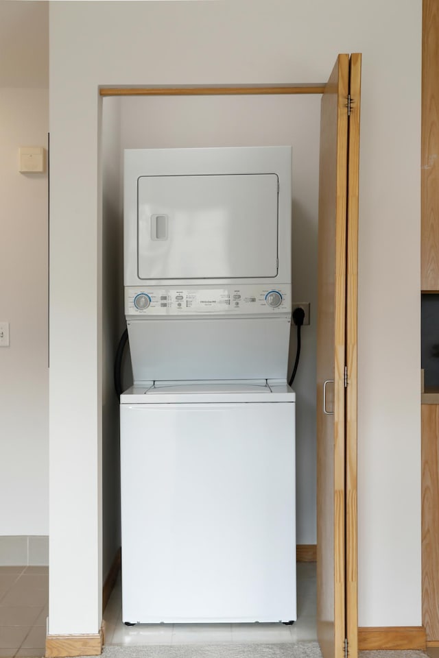 laundry room featuring stacked washer / drying machine