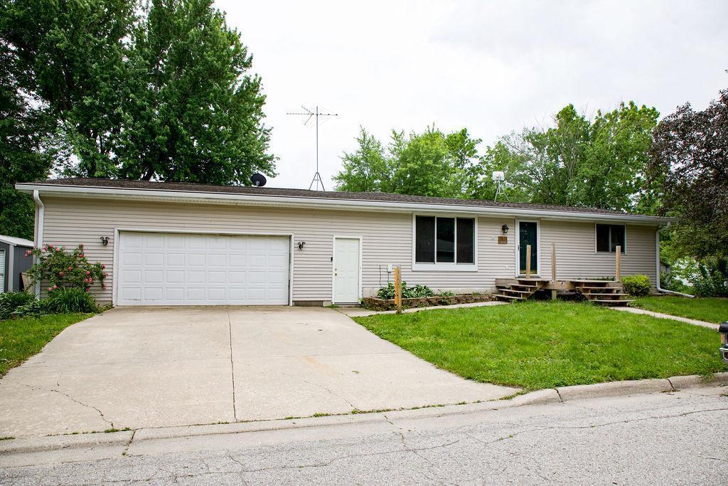 ranch-style home featuring a garage and a front lawn