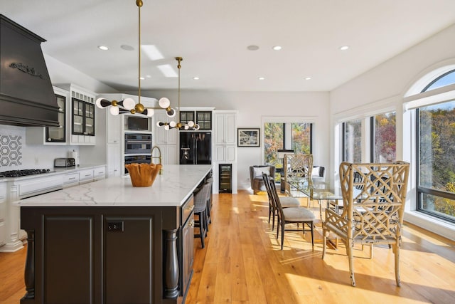 kitchen featuring light hardwood / wood-style floors, pendant lighting, and a kitchen island with sink