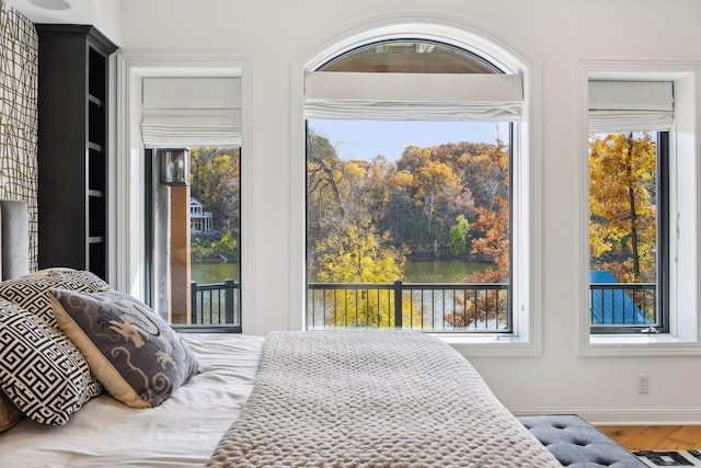 bedroom featuring a water view and hardwood / wood-style flooring