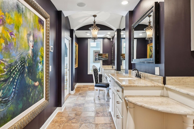 bathroom featuring vanity, lofted ceiling, and a chandelier