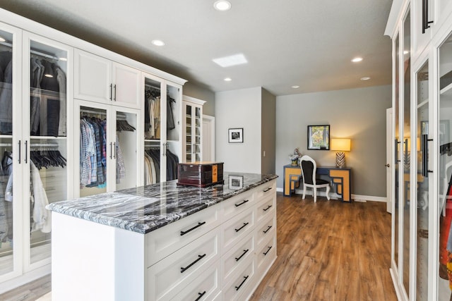 kitchen featuring dark stone countertops, white cabinets, a center island, and dark hardwood / wood-style flooring