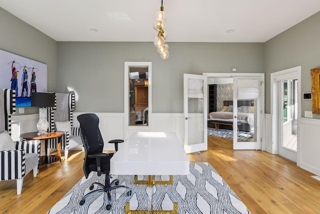 home office with french doors and light hardwood / wood-style flooring