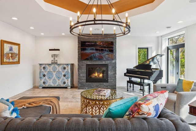 living room featuring a chandelier and a stone fireplace