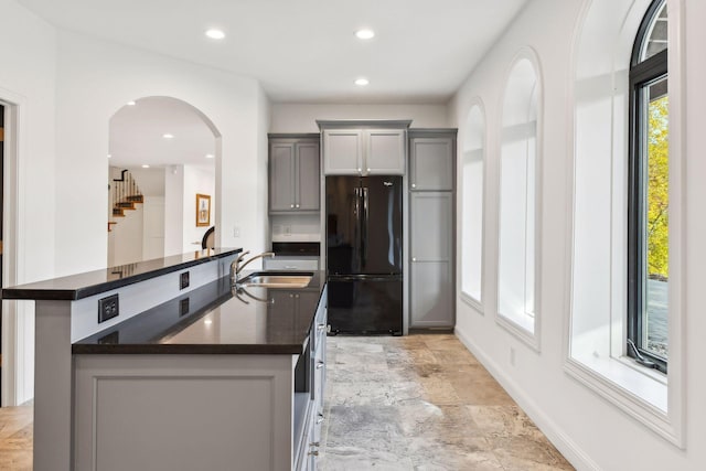 kitchen featuring gray cabinetry, sink, and black fridge