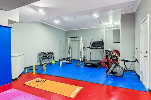 workout area featuring crown molding