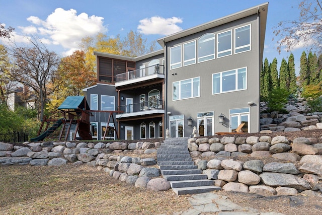 rear view of house with a balcony and a playground