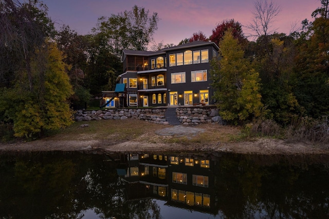 back house at dusk with a balcony