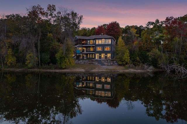 back house at dusk with a water view