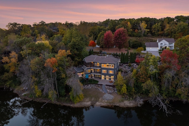 aerial view at dusk featuring a water view