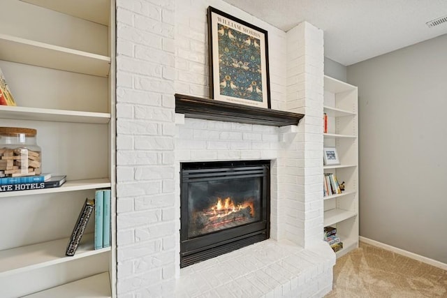 living area featuring a brick fireplace, carpet flooring, visible vents, and baseboards