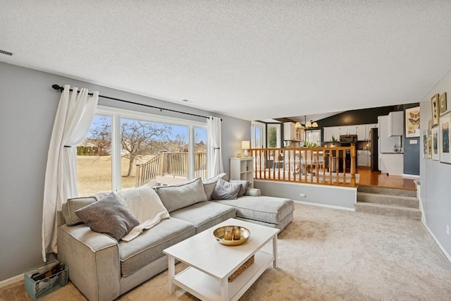 living room featuring visible vents, light colored carpet, a textured ceiling, and baseboards