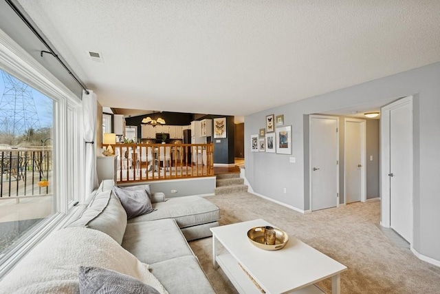 living room with baseboards, carpet, visible vents, and a textured ceiling