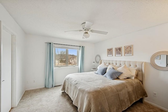 bedroom with carpet floors, ceiling fan, baseboards, and a textured ceiling