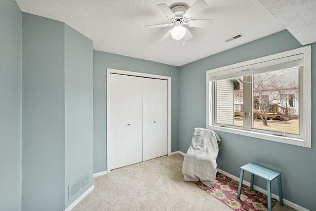 sitting room with baseboards, visible vents, and carpet flooring