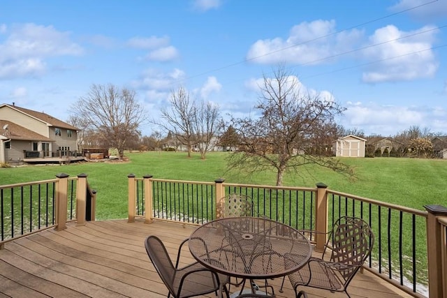 deck featuring an outbuilding, a lawn, outdoor dining space, and a storage unit