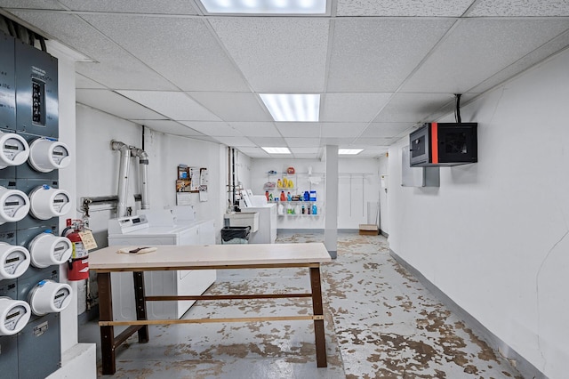 basement featuring a paneled ceiling and separate washer and dryer