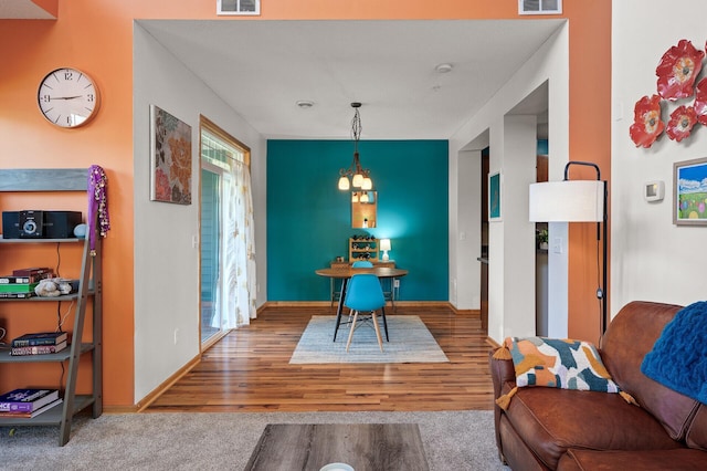 dining space featuring hardwood / wood-style flooring and a notable chandelier