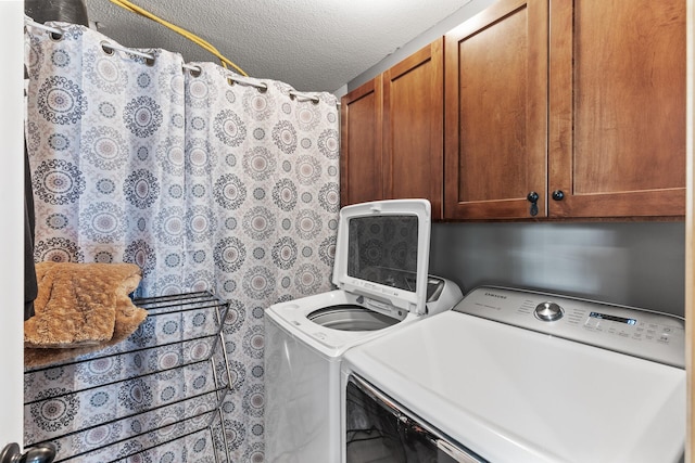 laundry area with independent washer and dryer, cabinets, and a textured ceiling