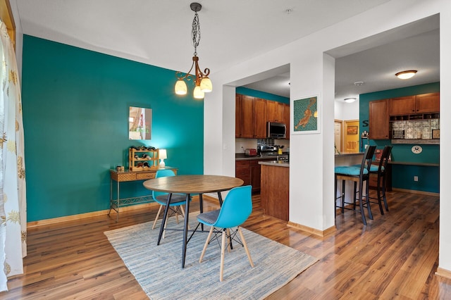 dining space featuring light wood-style flooring and baseboards