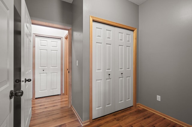 corridor featuring baseboards and light wood-style floors