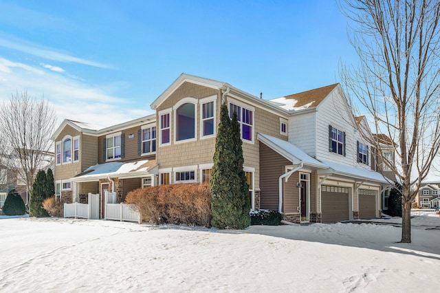 view of front of property featuring a residential view, a garage, and fence