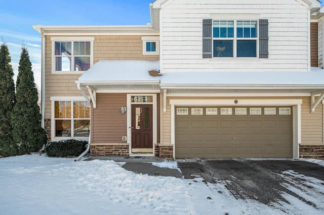 view of front of property with stone siding, driveway, and a garage