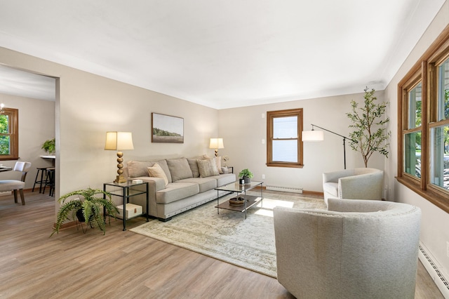 living room featuring a baseboard radiator, hardwood / wood-style floors, and a wealth of natural light