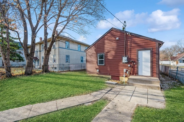 back of house featuring a garage and a lawn